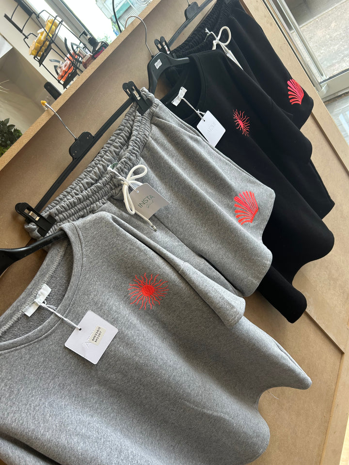 Gray sweatpants with tags on a wooden surface
