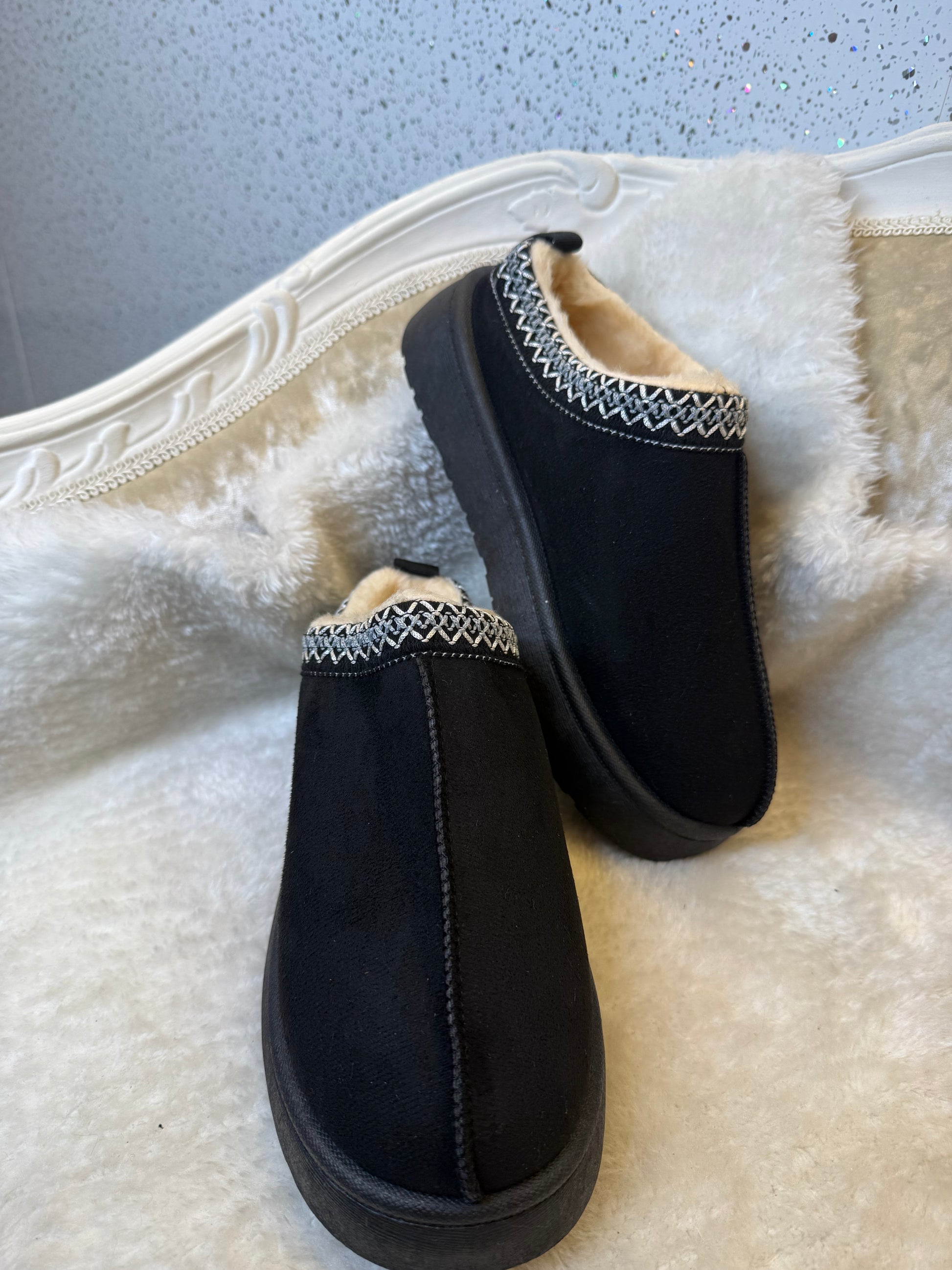 Black faux slippers with white fur lining