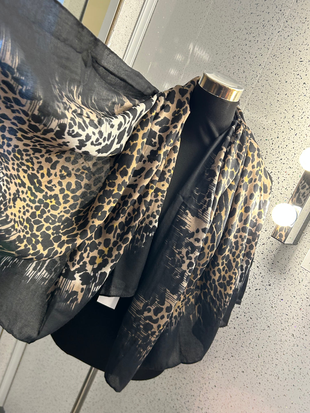 A leopard print thin scarf with a black border