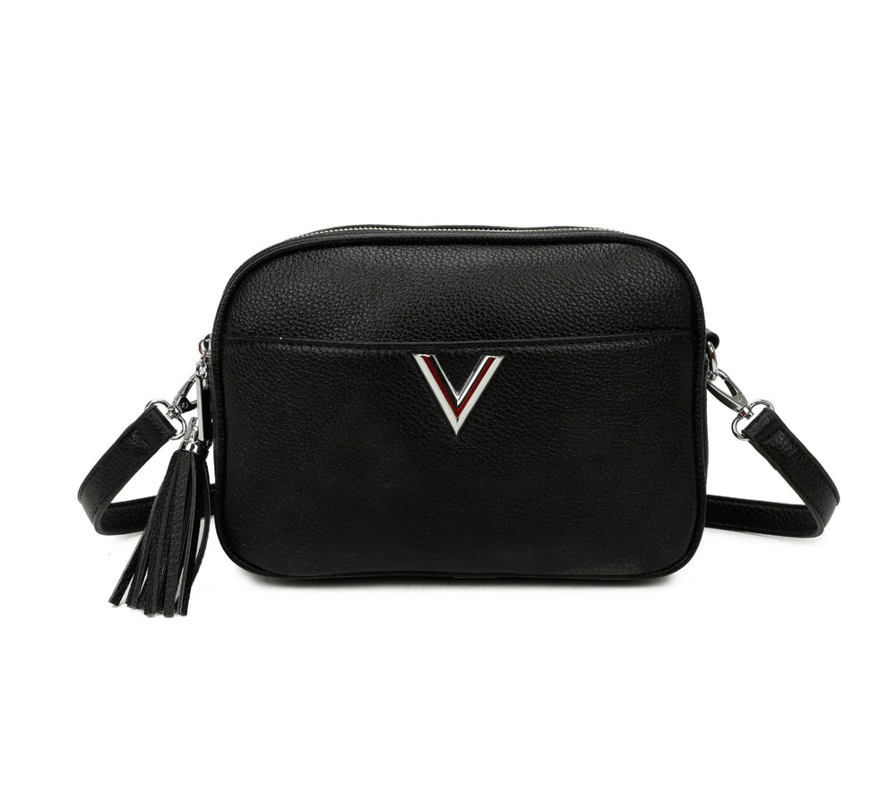 A black faux leather crossbody bag with a double zip closure, silver tone metal hardware, and an adjustable long strap. It features a front pocket,