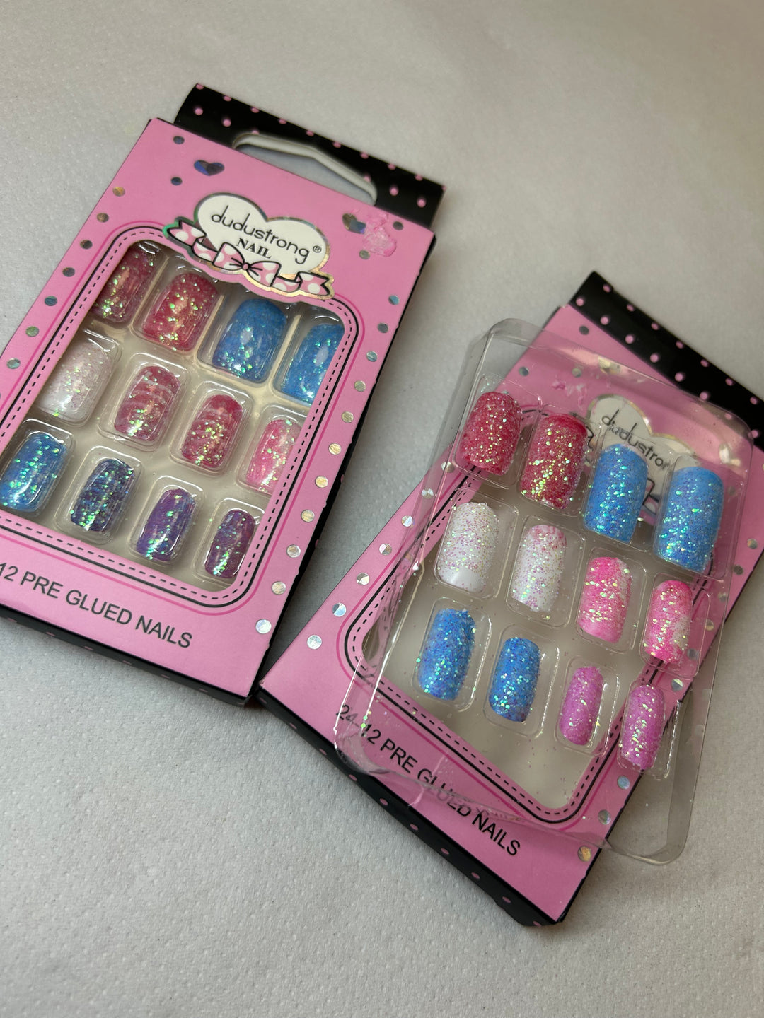 Set of glittery false nails in a pink packaging.