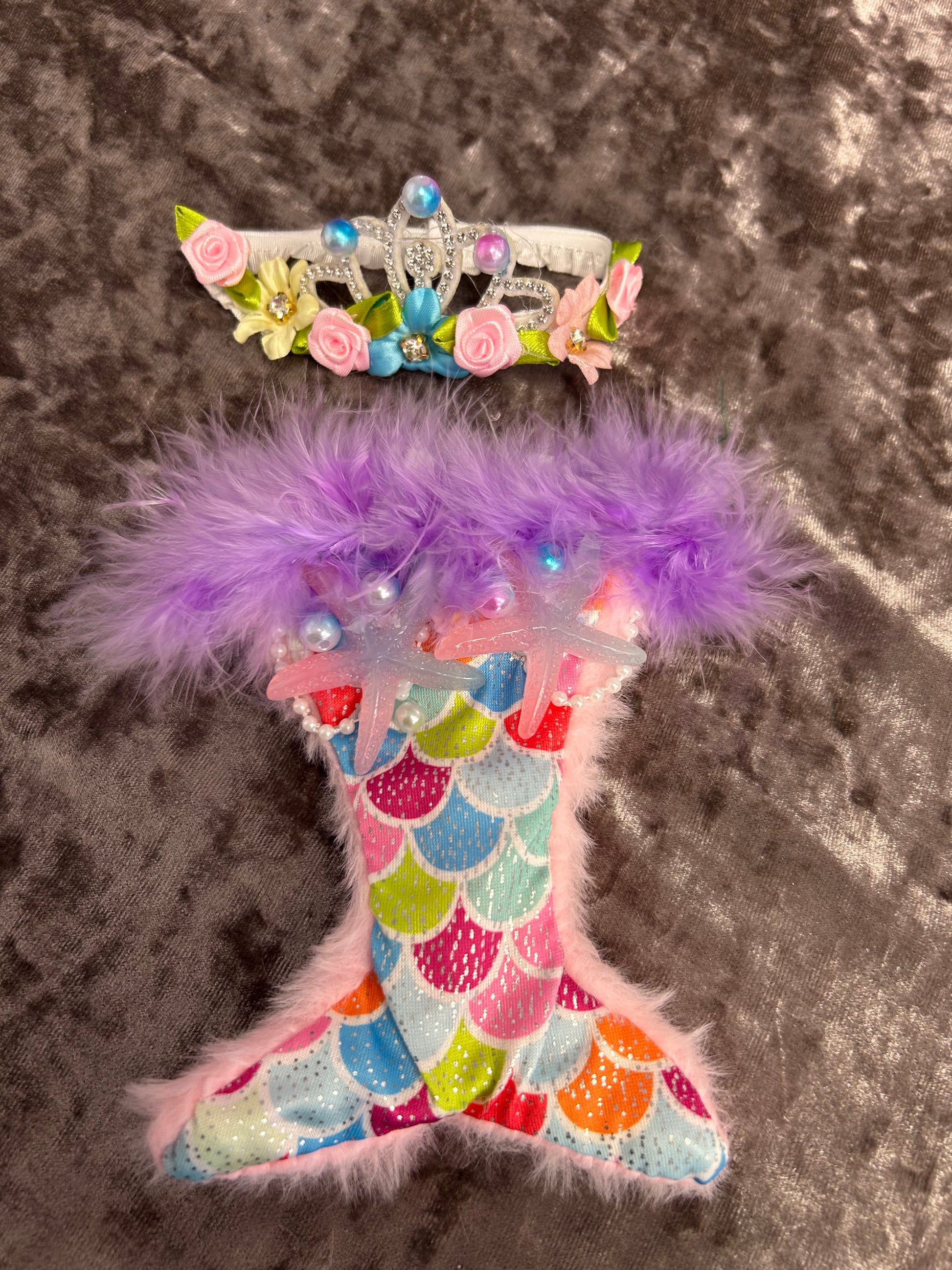 Decorative headband with floral and feather details on a textured surface