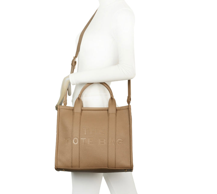 A beige tote bag with embossed ‘The Tote Bag’ text, structured design with top handles and detachable shoulder strap