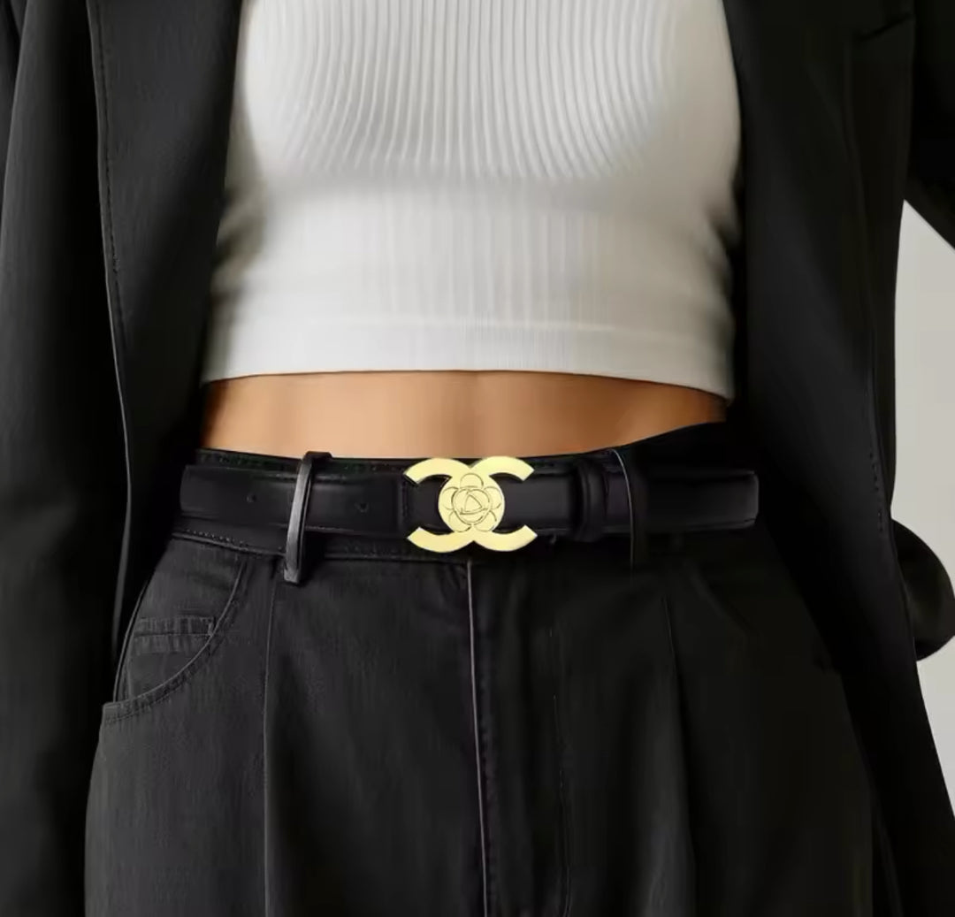A faux leather black belt with a gold buckle,