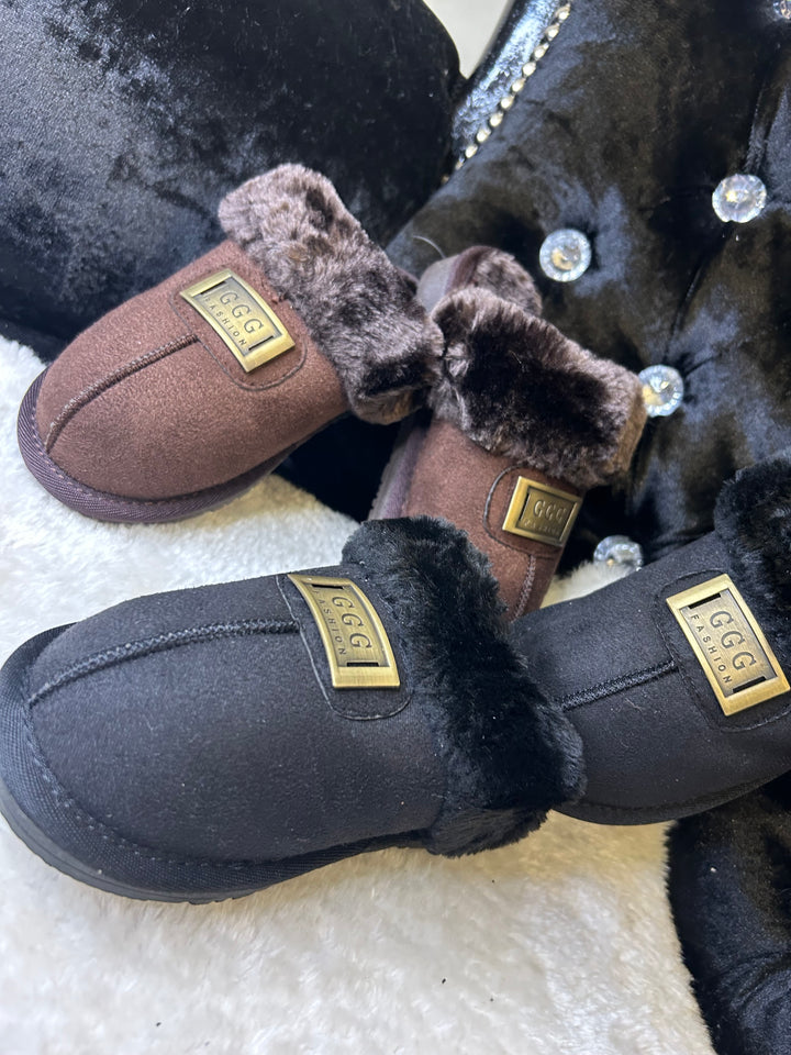 a choice of chocolate brown or black closed toe slip on faux fur slippers with gold buckle on the front