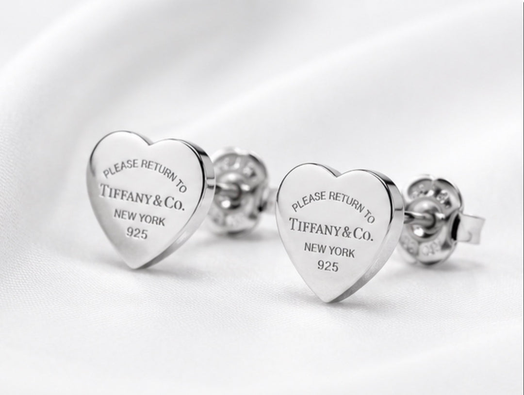 Silver heart-shaped stud earrings with engraved detailing