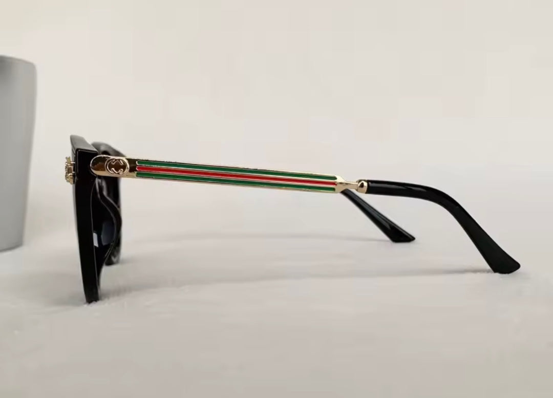 Black sunglasses with gold bee embellishment and green red stripe arms