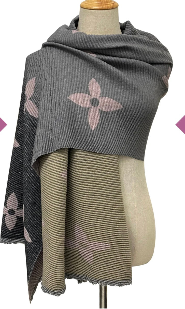A wool scarf with pleated texture and ombre design, featuring shades of grey and pink flower prints, 