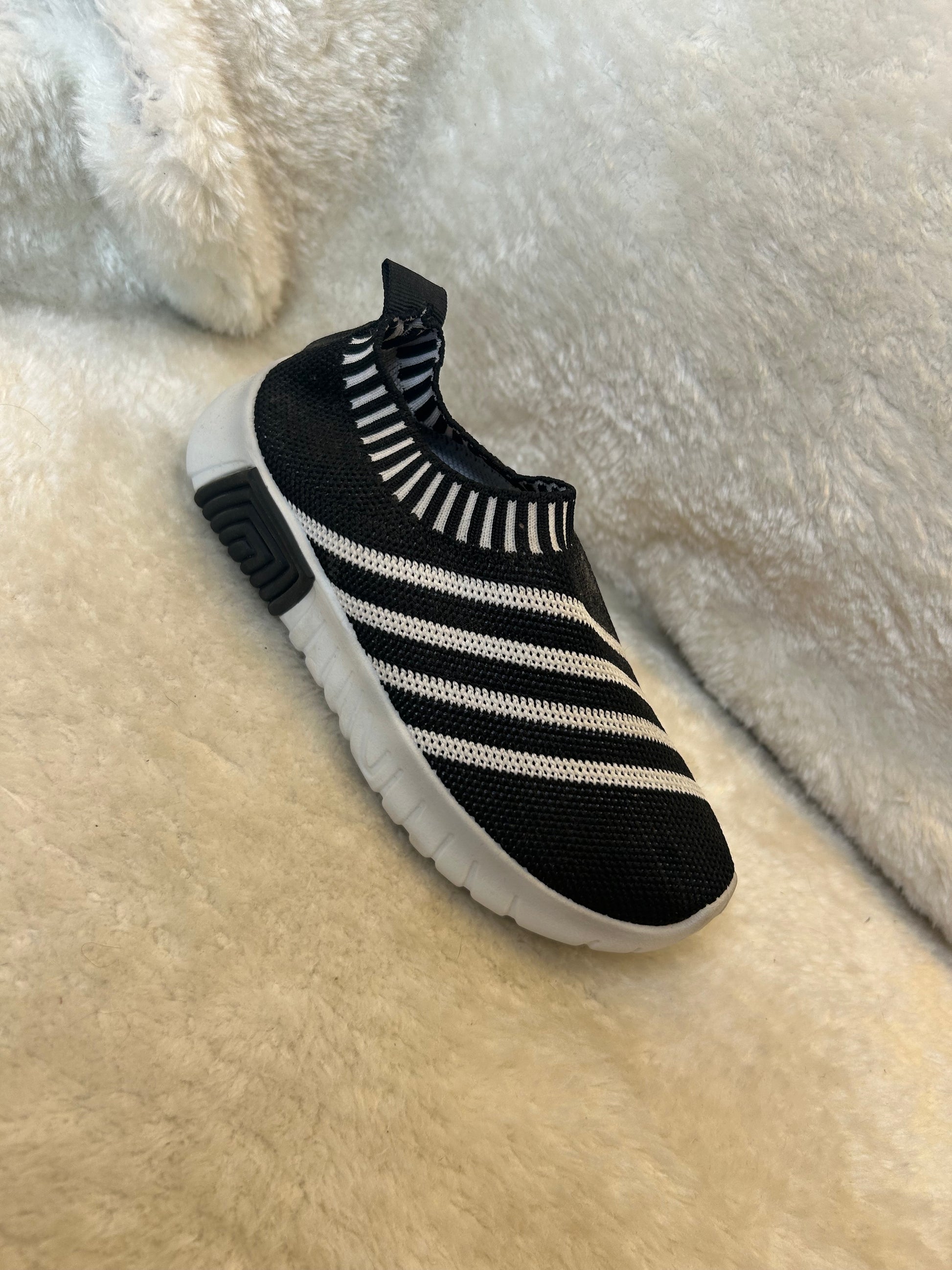 Children’s black & white slip on trainers with white soles 