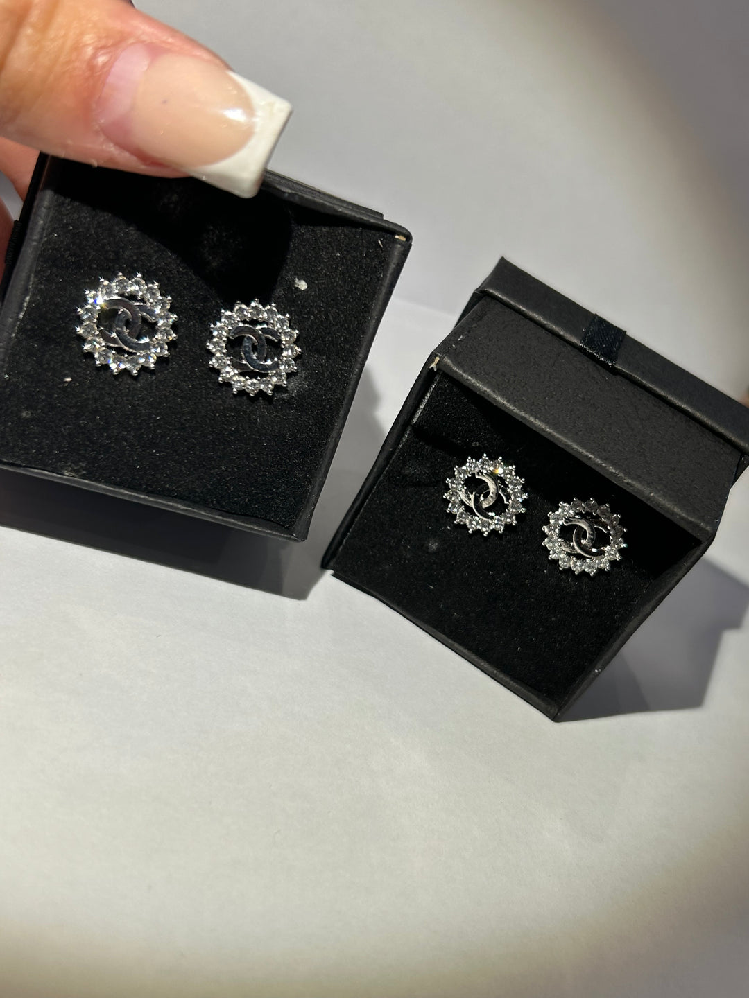 A pair of stud crystal surround earring with letter detail in the middle 