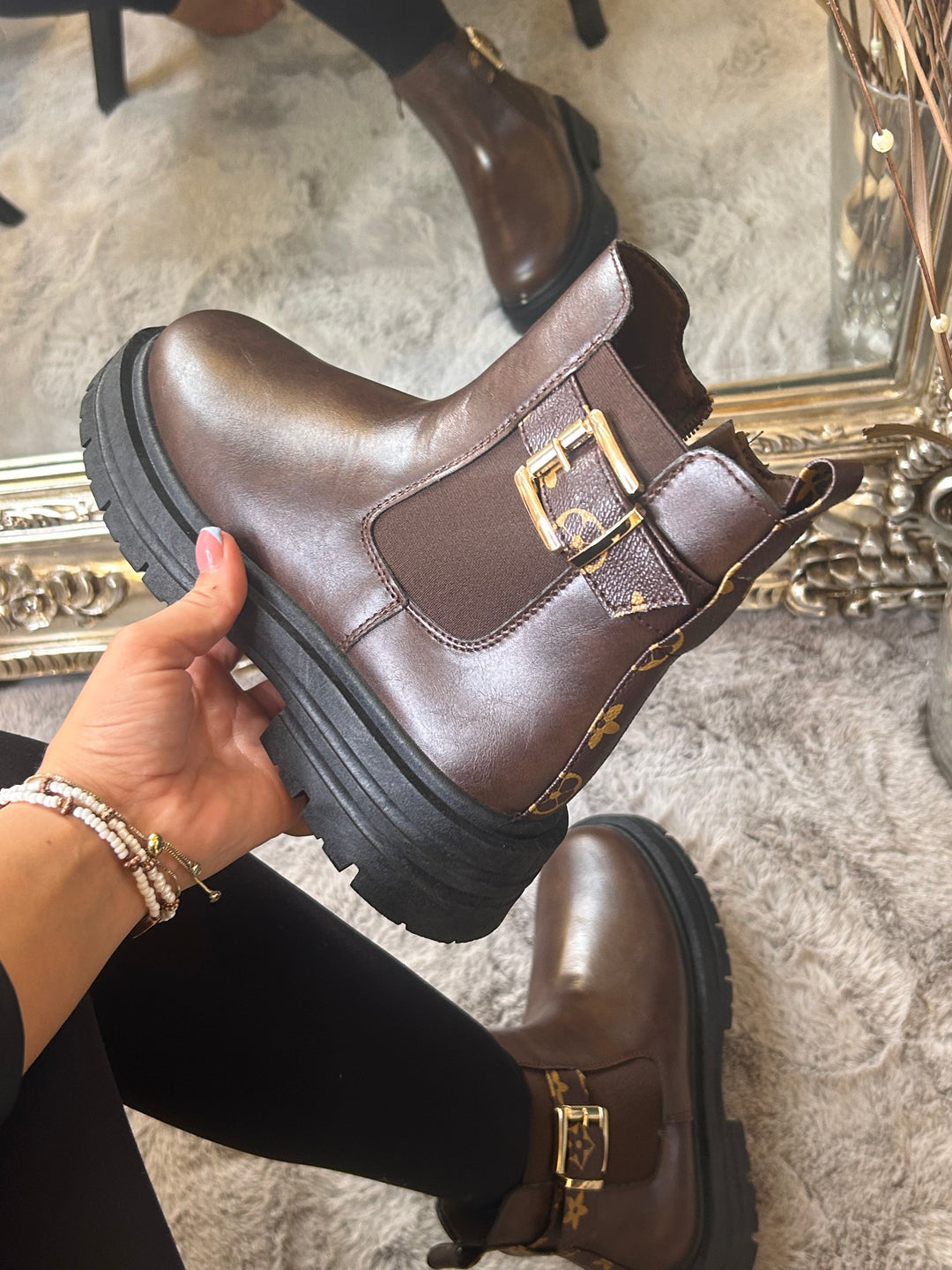 Chunky brown ankle boots with gold buckle detail, elastic side panels and thick black soles