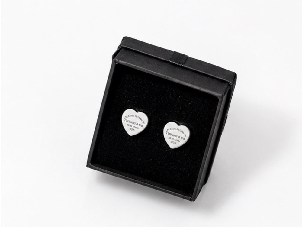 Silver heart-shaped stud earrings with engraved detailing