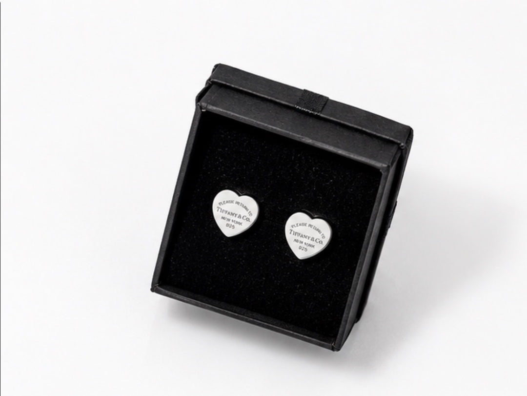 Silver heart-shaped stud earrings with engraved detailing