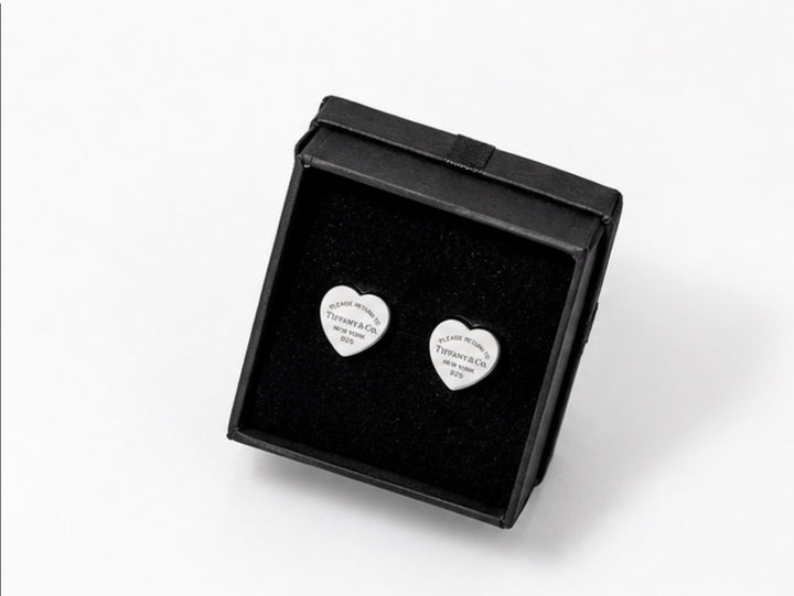 Silver heart-shaped stud earrings with engraved detailing