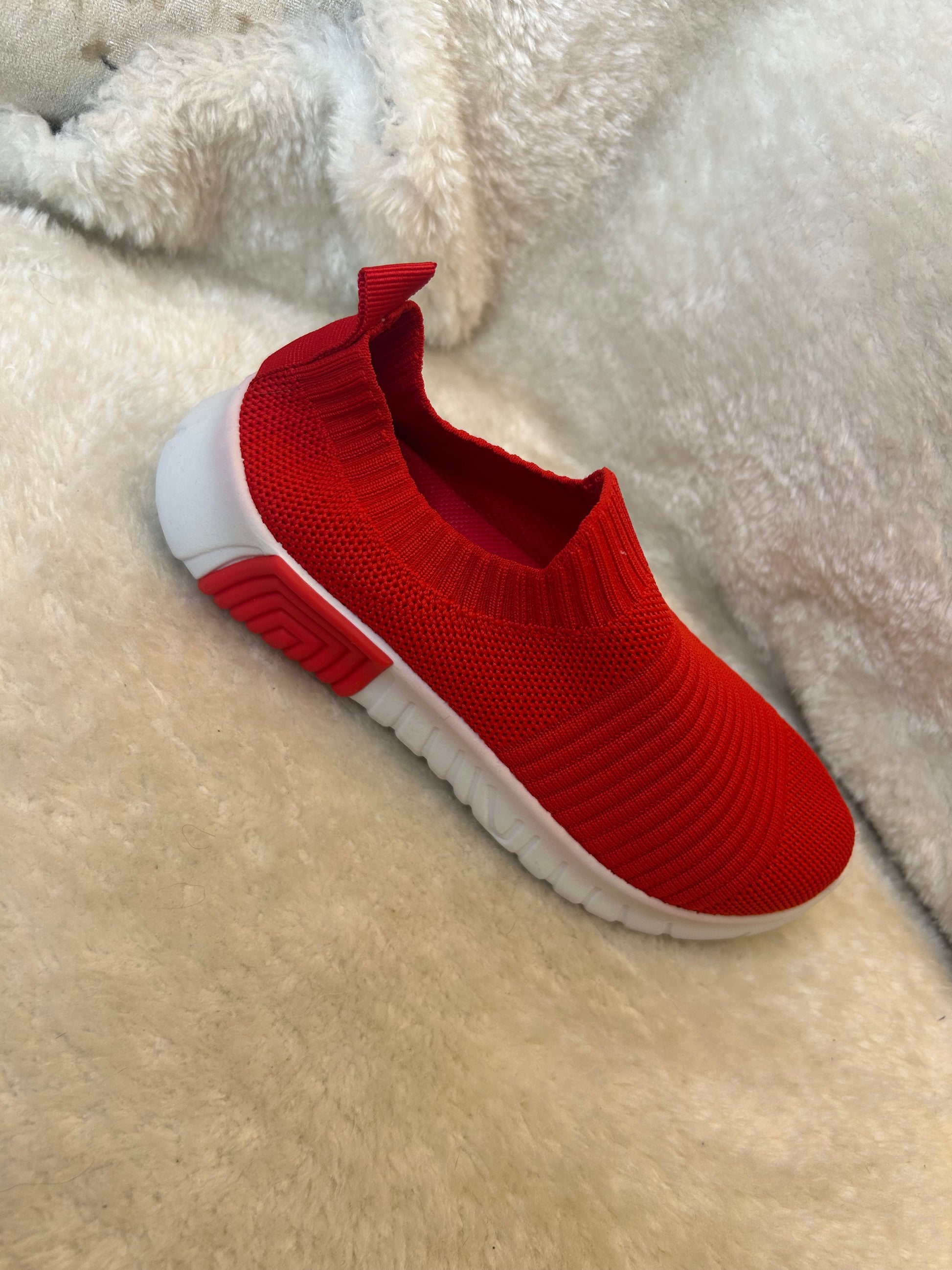 Children’s red slip on trainers with white soles 