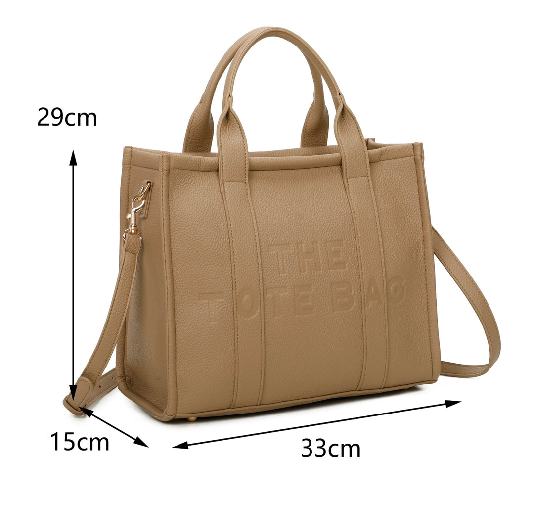 A beige tote bag with embossed ‘The Tote Bag’ text, structured design with top handles and detachable shoulder strap