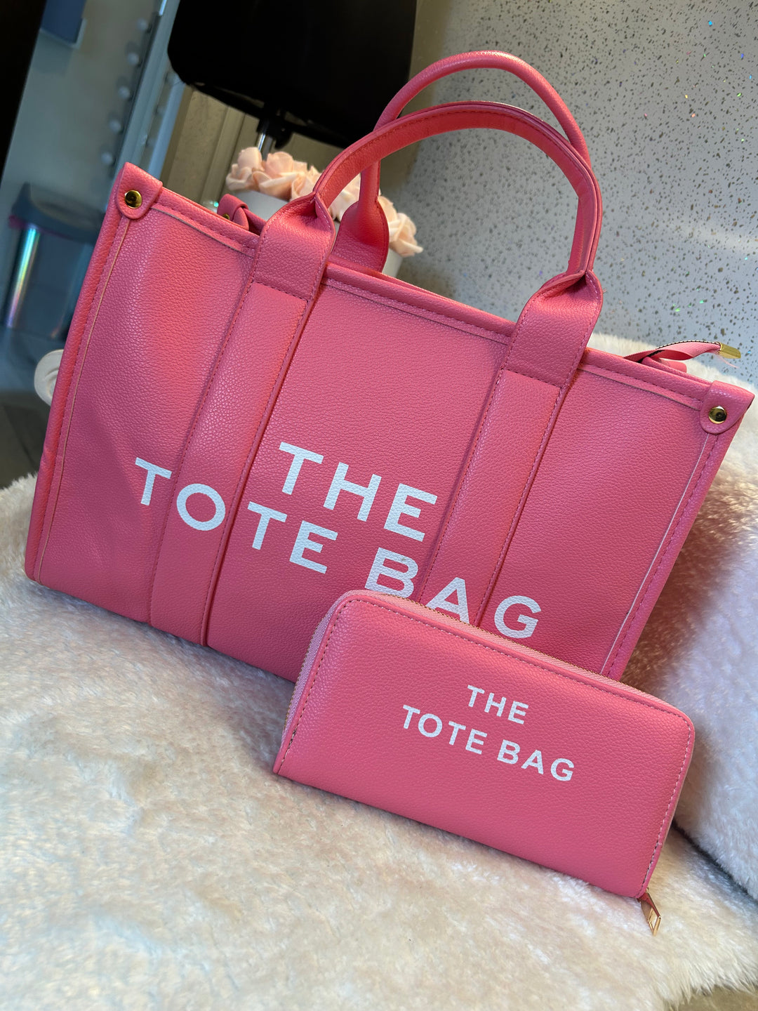 Pink bag and purse set with “the tote bag” text in white with gold hardware