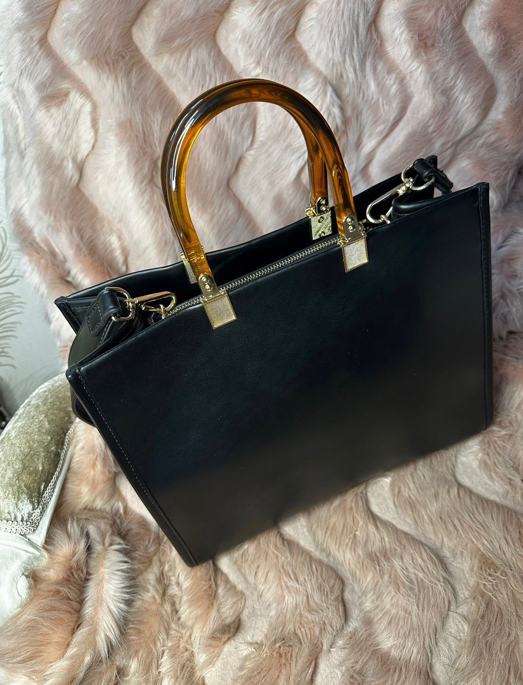 back of top view of black faux leather tote bag with the cbs logo on the front