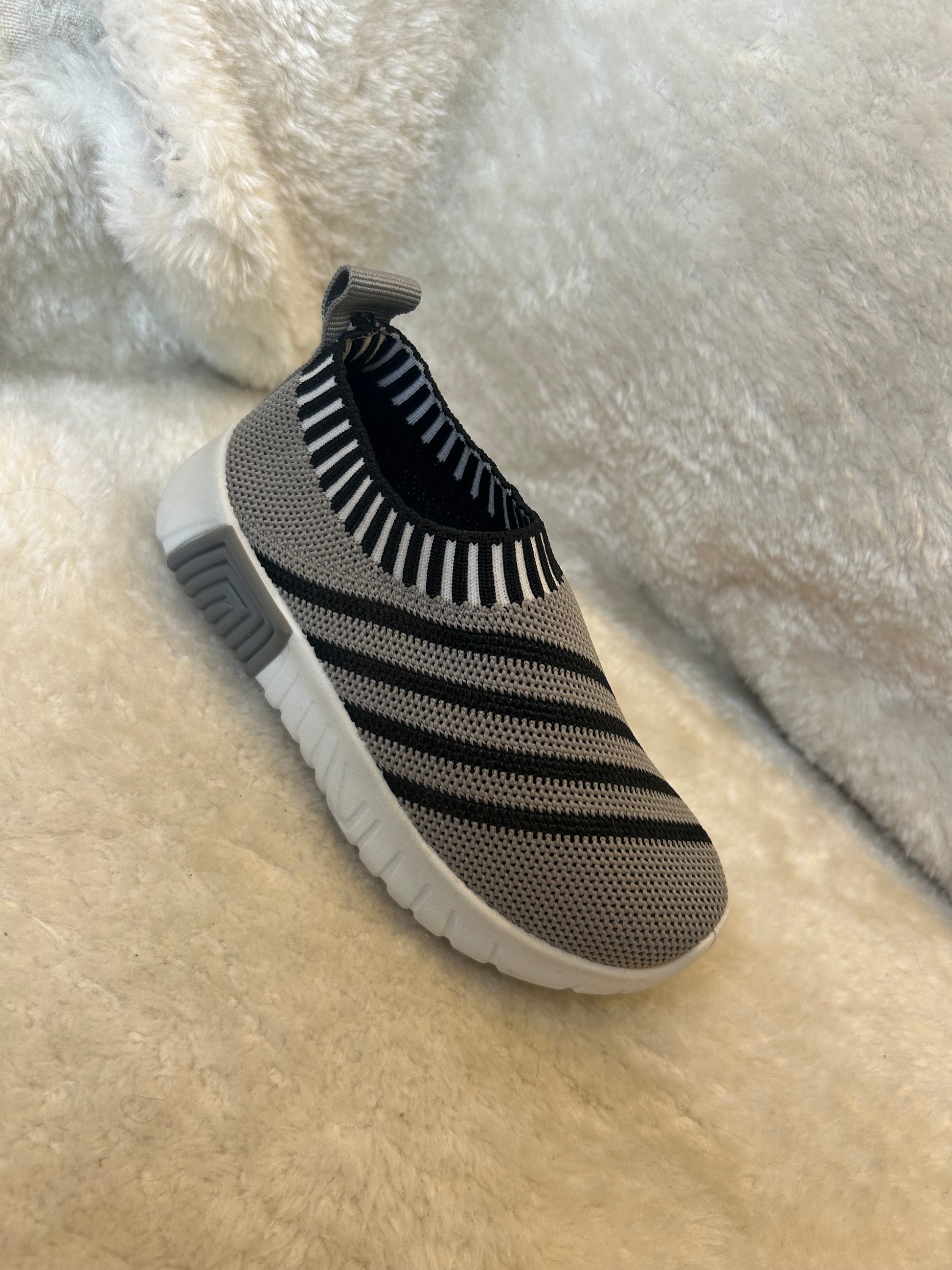 Children’s grey and black slip on trainers with white soles 