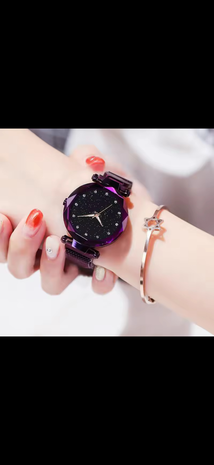A purple wristwatch with a glitter face with a magnetic closure strap