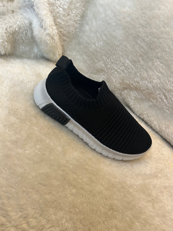 Children’s black slip on trainers with white soles 
