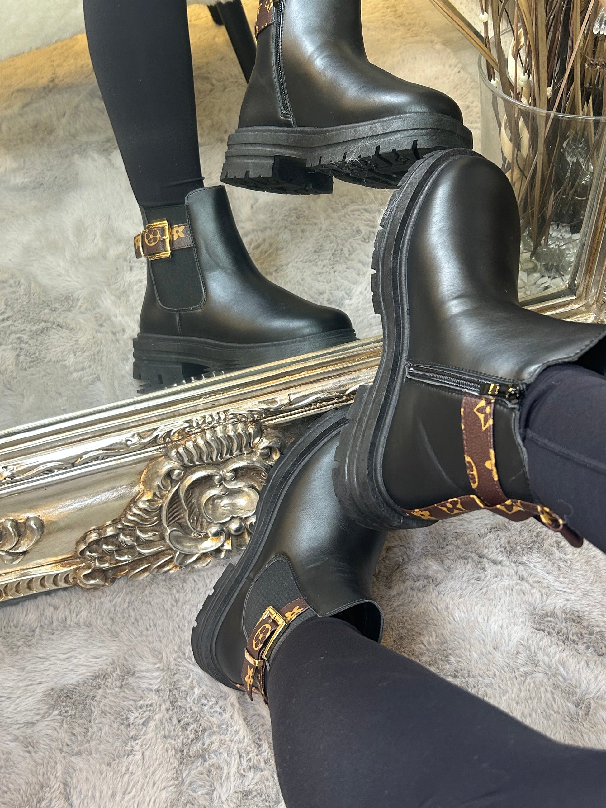 Chunky black ankle boots with gold buckle detail, elastic side panels and thick black soles. 