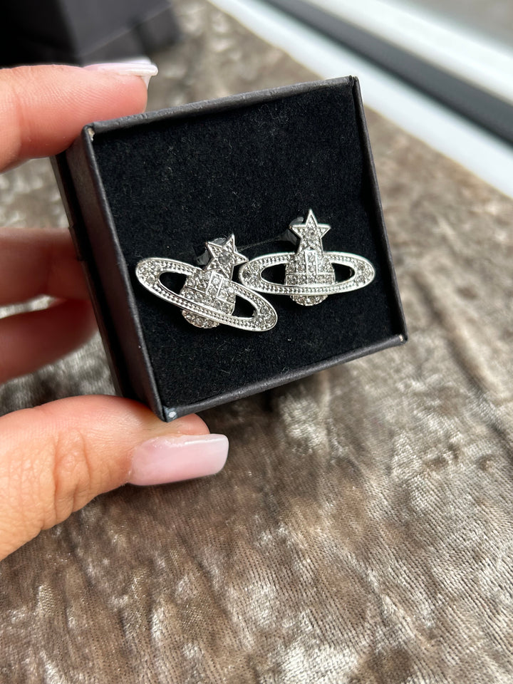 A pair of silver-colored star planet earrings 