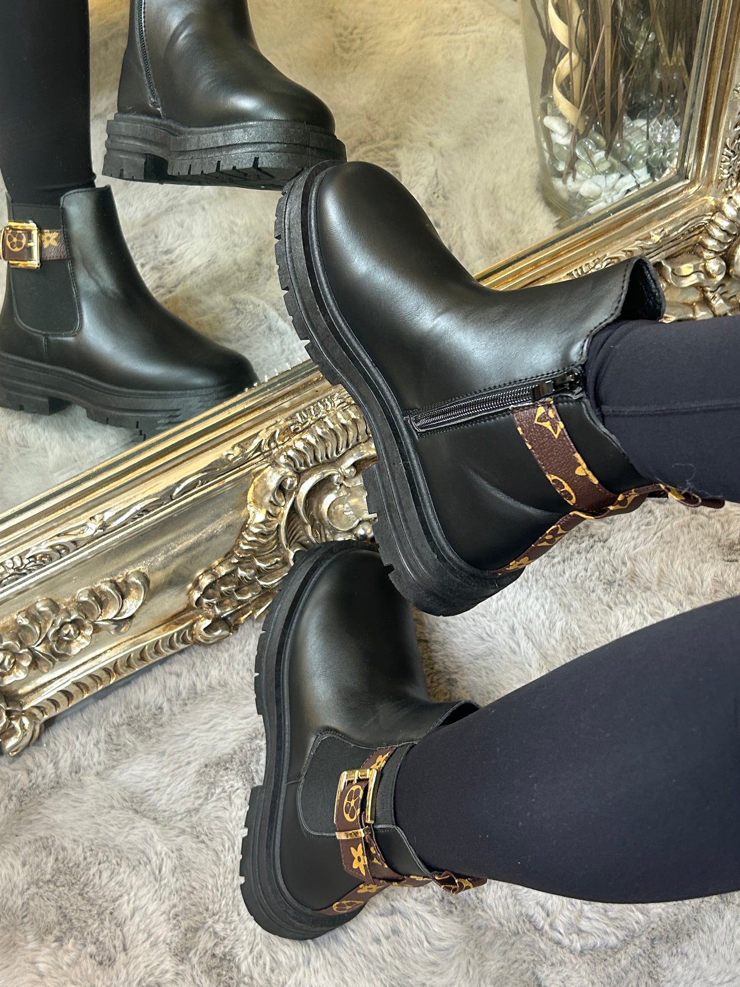 Chunky black ankle boots with gold buckle detail, elastic side panels and thick black soles. 