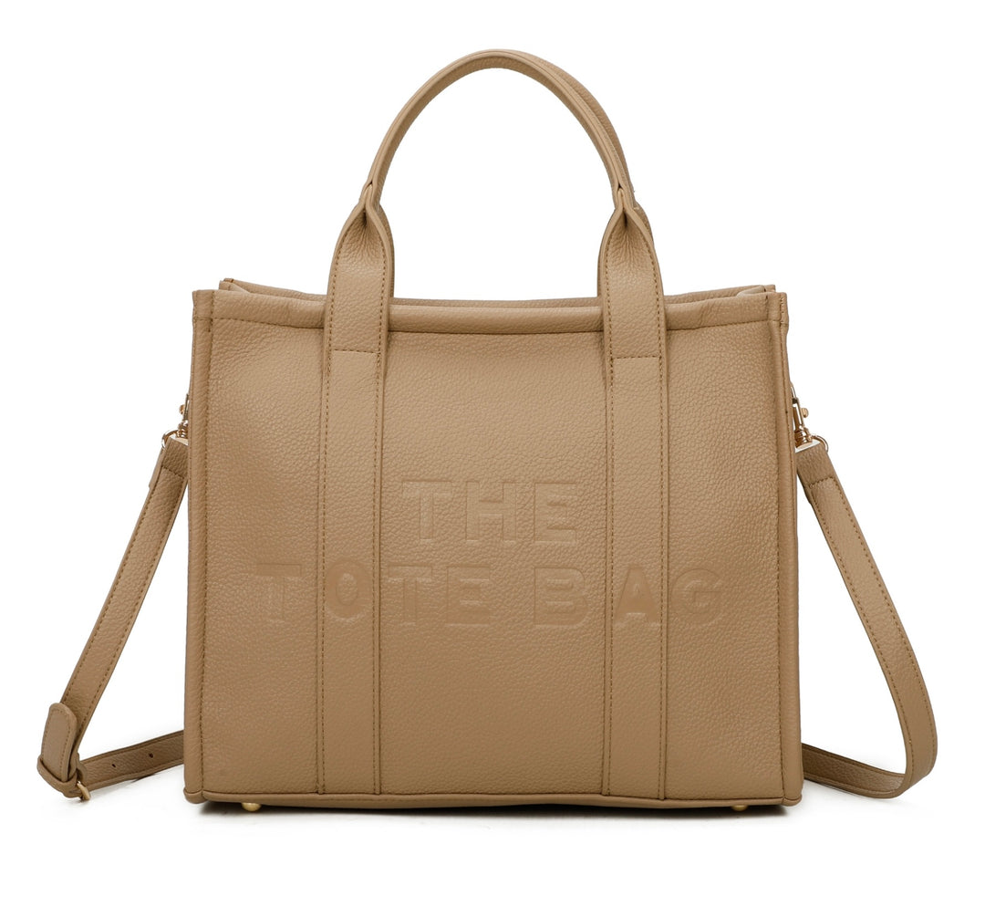 A beige tote bag with embossed ‘The Tote Bag’ text, structured design with top handles and detachable shoulder strap