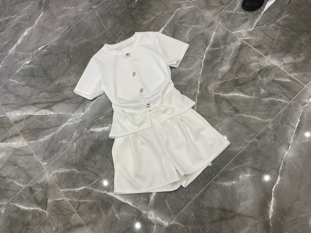 White co ord set flat lay with gold button detail top and matching shorts