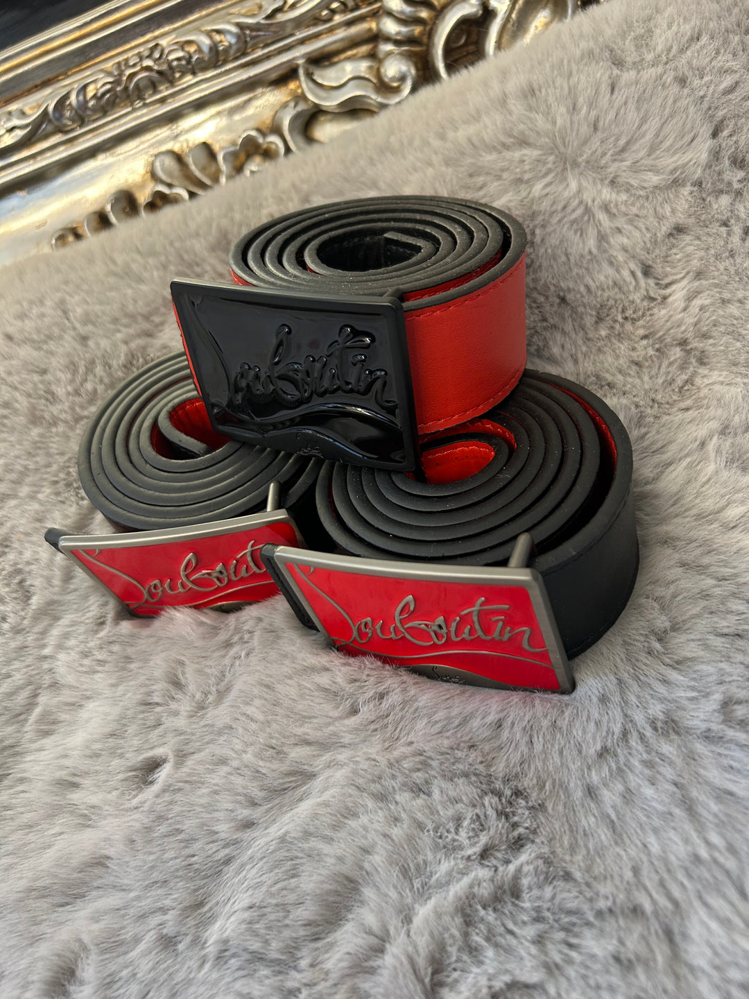 Two belts with red and black colour scheme one with black buckle