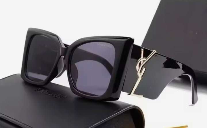 Black chunky sunglasses with a gold logo 
