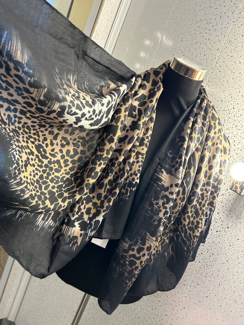 A leopard print thin scarf with a black border