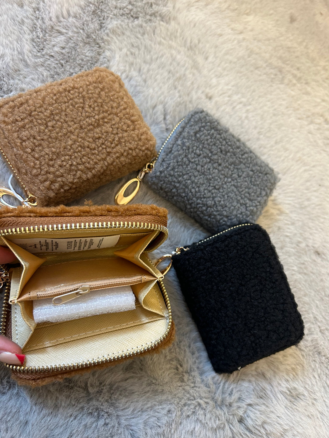 A fuzzy mini purses with gold zip detailing 
