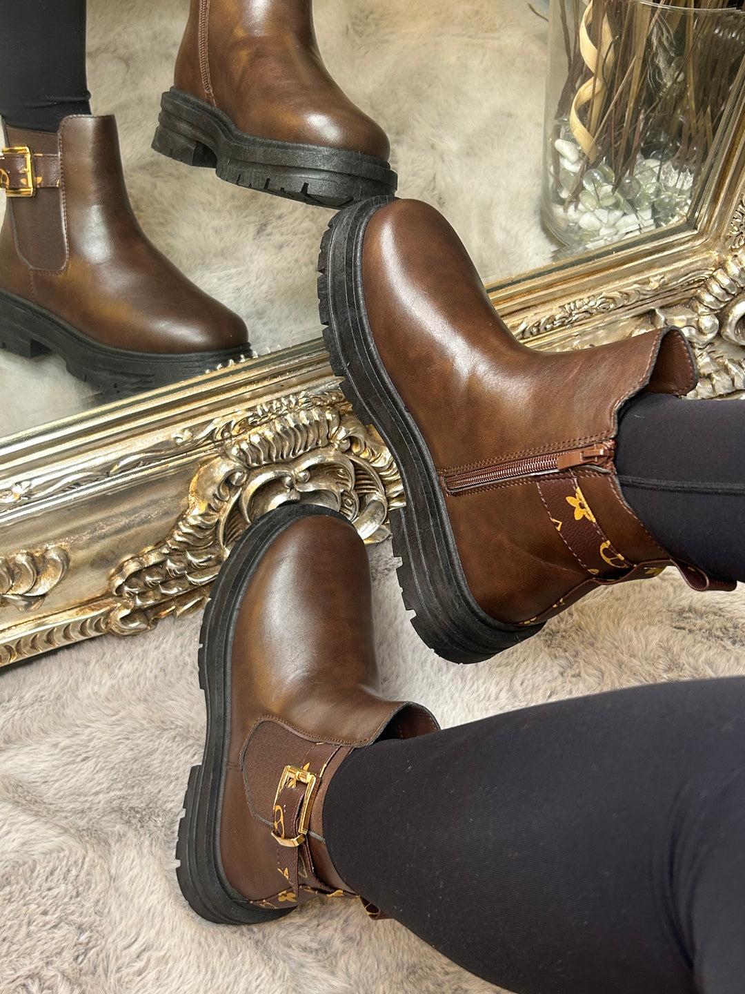 Chunky brown ankle boots with gold buckle detail, elastic side panels and thick black soles