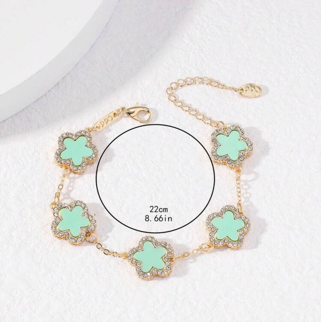     Adjustable gold bracelet with five mint clover charms and crystal detailing