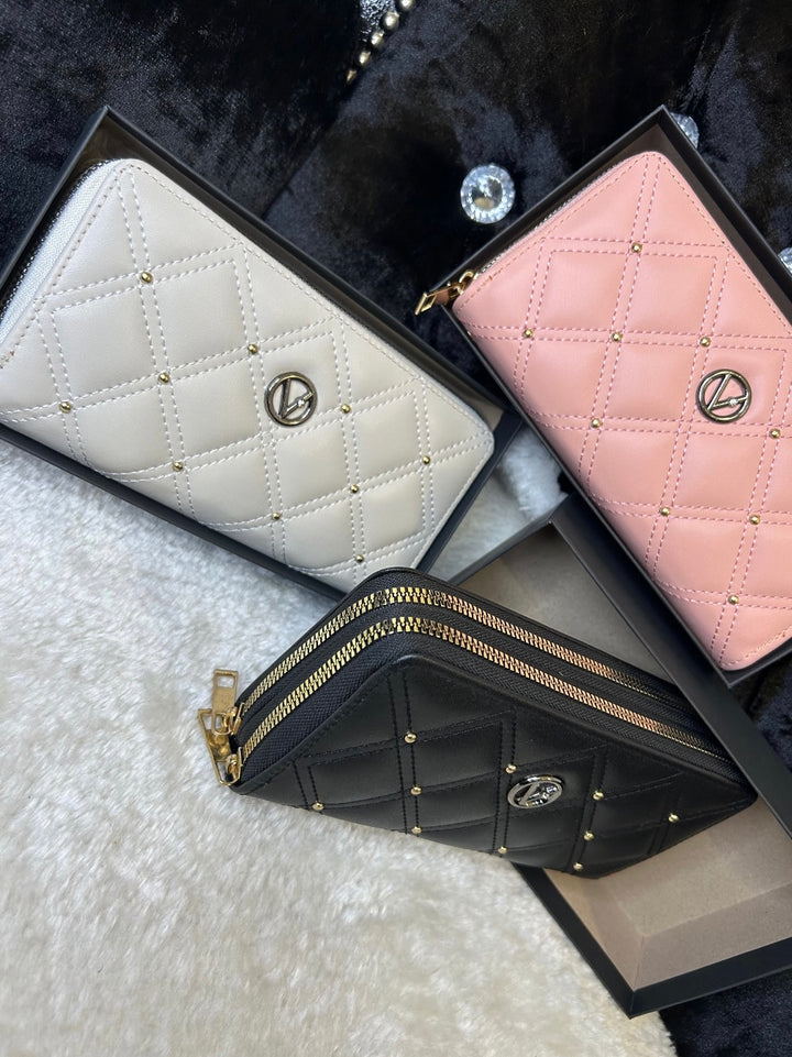Three quilted leather purses in pink, white, and black, displayed side by side with zip compartments visible.
