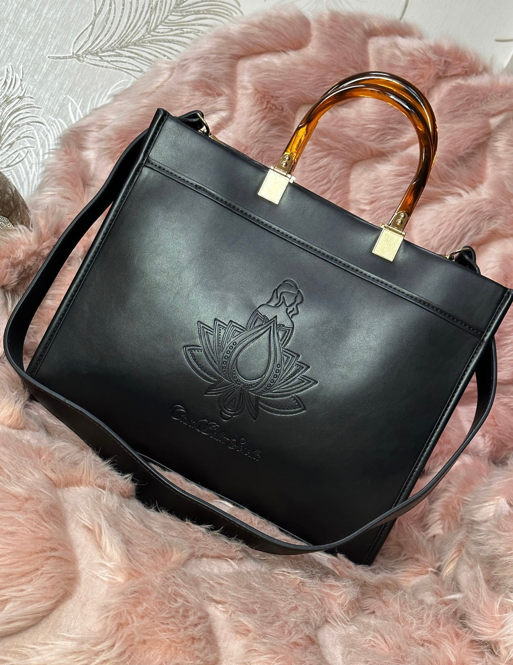 black faux leather tote bag with the cbs logo on the front