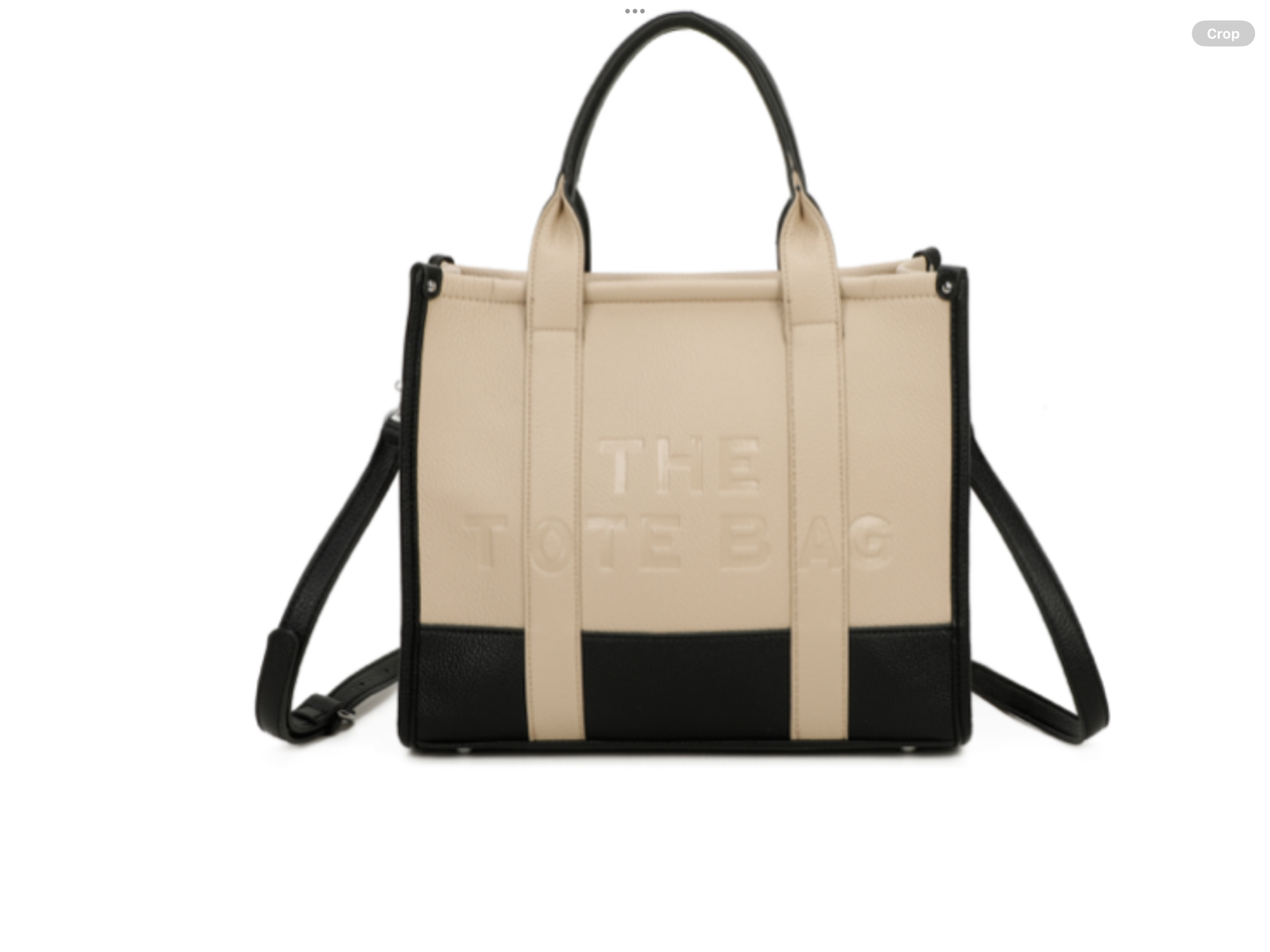 Beige and black handbag with 'The tote bag ‘ embossed into the front with silver hard wear 