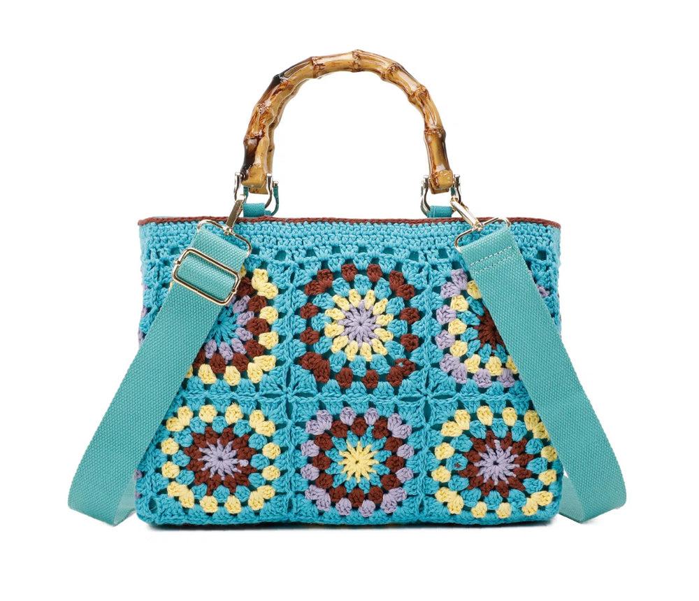 Blue crochet grab bags with bamboo handles and gold tone metal hardware.