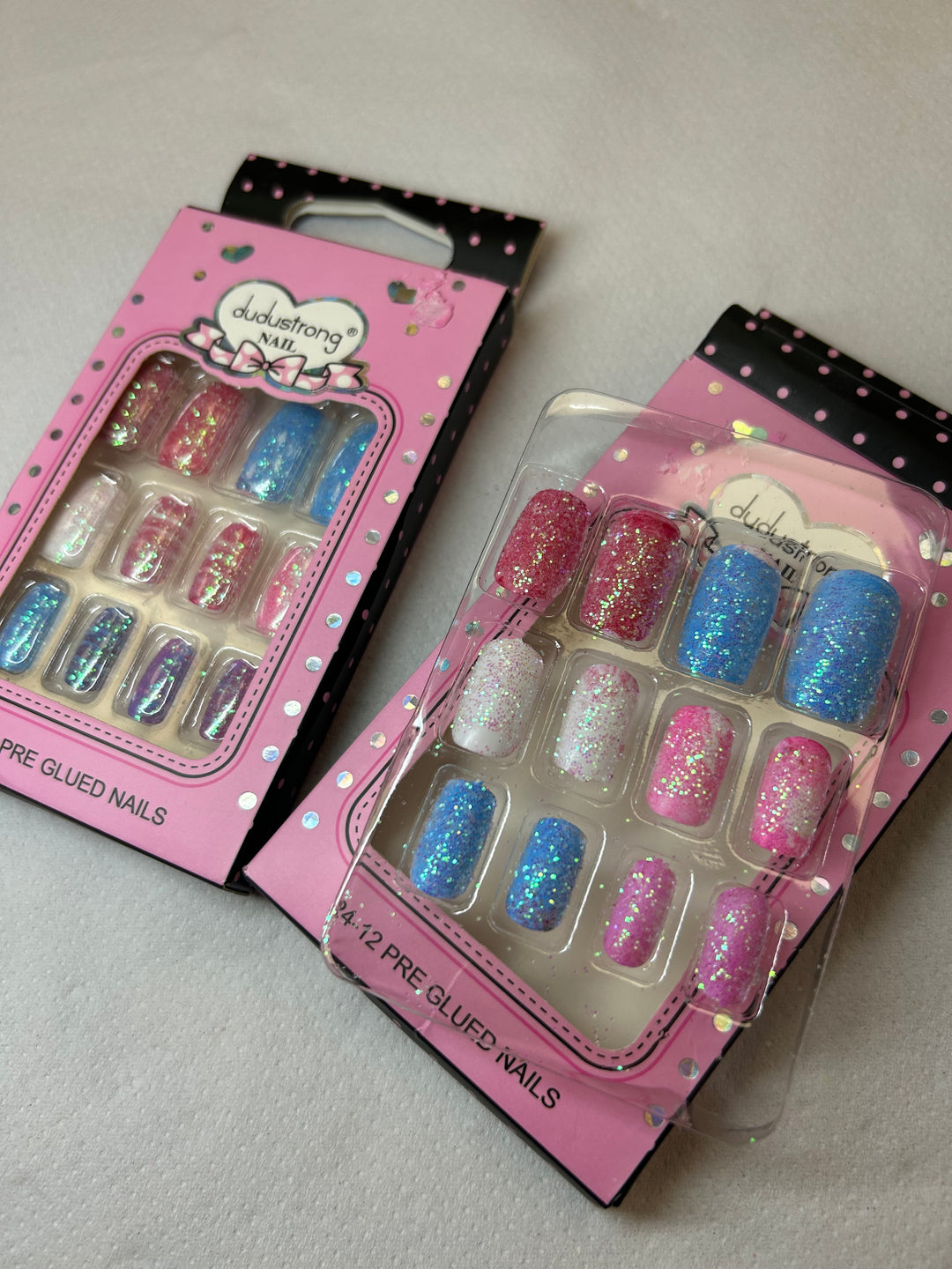 Two packages of false nails with colorful glittery tips