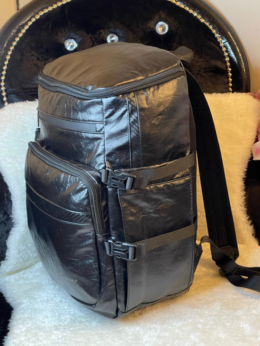 large black leather-look backpack with multiple zip compartments, adjustable straps and modern design, practical travel and work bag