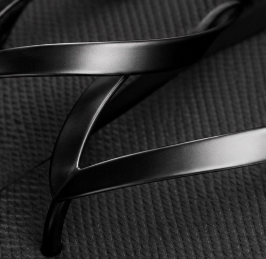 Black flip flops with glossy black straps and textured soles 
