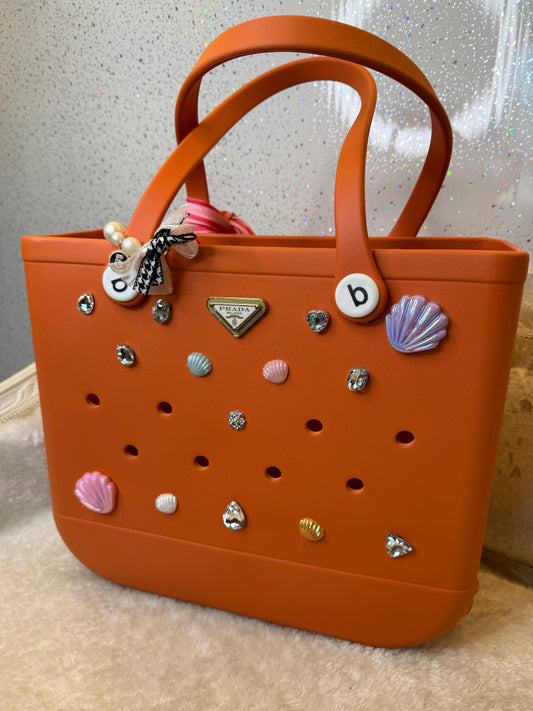 Orange handbag with decorative elements 