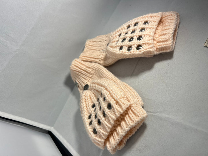 A pair of baby pink knitted mittens with stud patterns