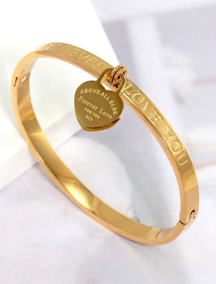     Gold three-piece stainless steel love bangle bracelet set with heart charms and crystal detailing.