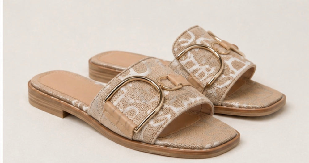 Rose gold monogram buckle sliders worn by model with slip on summer sandal design