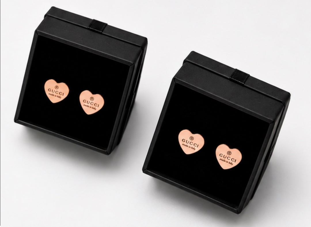 Rose gold heart stud earrings displayed in black jewellery gift boxes 