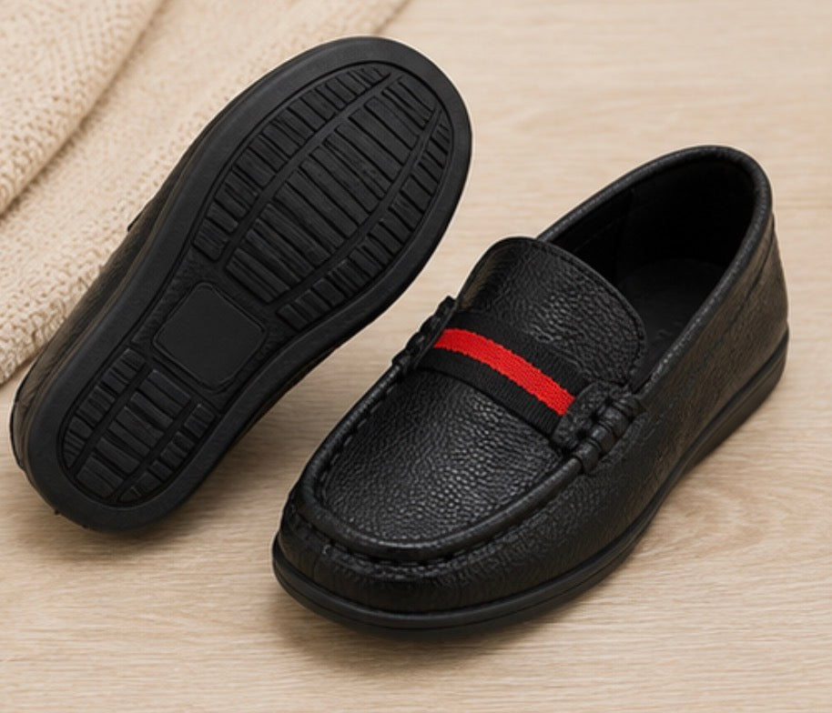 Black kids slip-on loafers with textured faux leather finish and red stripe detail