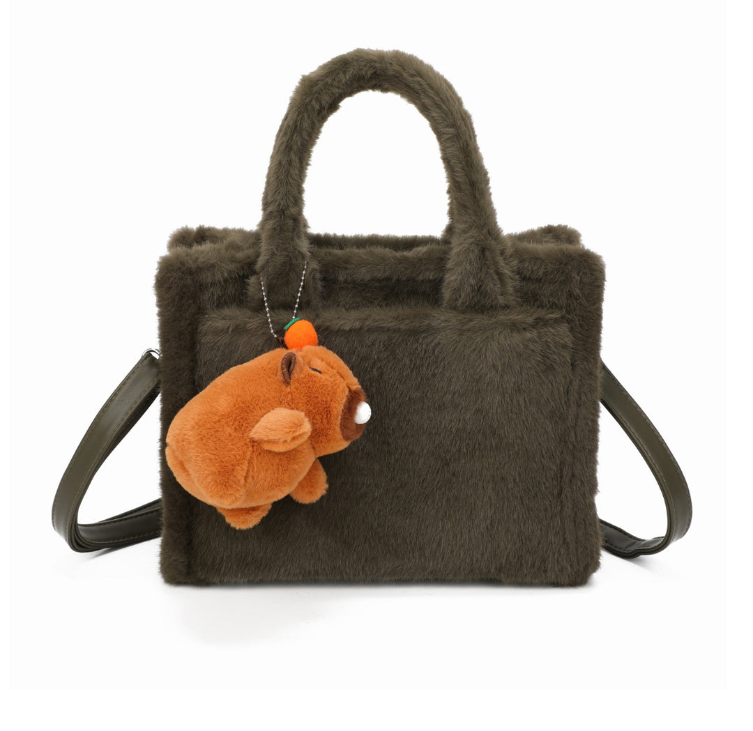 Green faux-fur tote bag with a small brown teddy bear keychain and matching handles and strap.